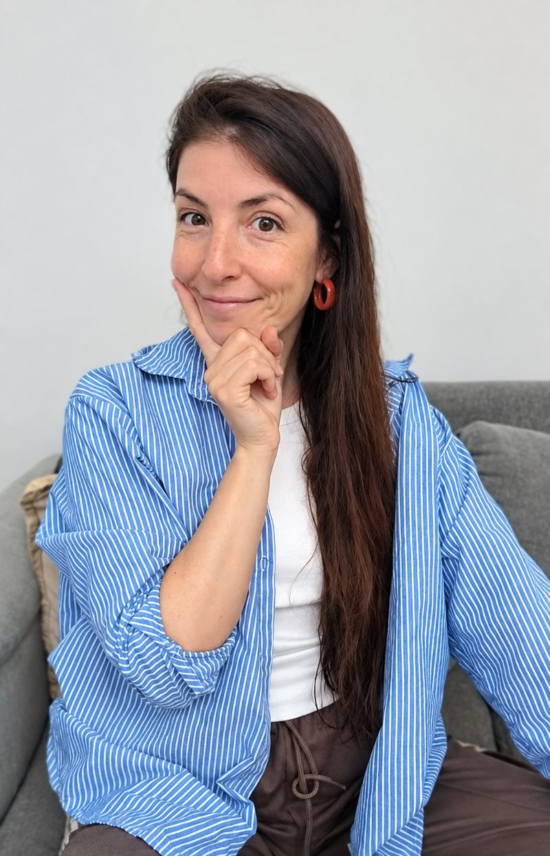 Dama sonriendo, con la mano en el mentón, como pensando una respuesta
